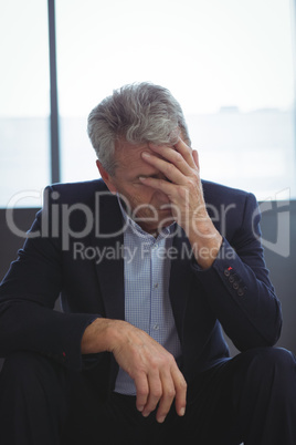 Depressed businessman sitting with hand on head