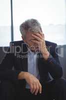 Depressed businessman sitting with hand on head
