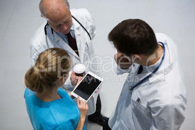Doctors and surgeon using digital tablet while having coffee