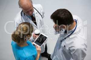 Doctors and surgeon using digital tablet while having coffee