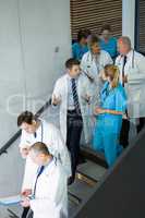 Group of doctors and surgeons interacting with each other on staircase