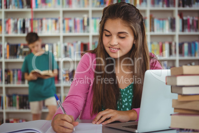 Schoolgirl doing homework in library