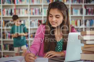 Schoolgirl doing homework in library