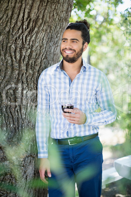 Man holding glass of wine in the park