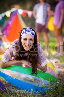 Portrait of woman leaning on beach ball at campsite