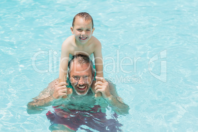 Portrait of father and son in swimming pool