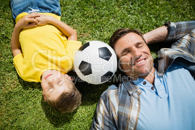 Father and son lying on grass in the park