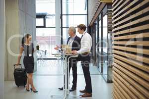 Executives standing with glasses of water to welcome their colleague