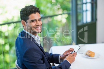 Happy businessman using mobile phone