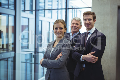 Business executives standing with arms crossed in the office