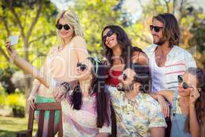 Group of friends taking selfie with mobile phone