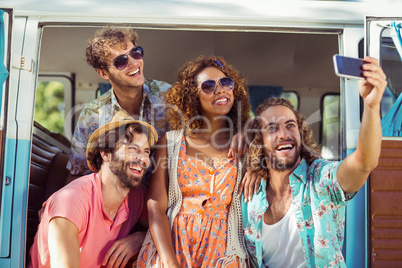 Group of happy friend taking a selfie in campervan