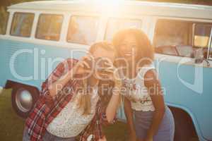 Two smiling friends photographing with camera