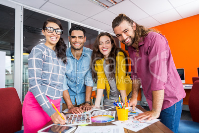 Smiling graphic designers working over photos at desk in office