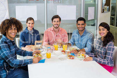 Portrait of smiling executives having breakfast