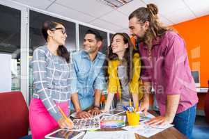 Smiling graphic designers working over photos at desk