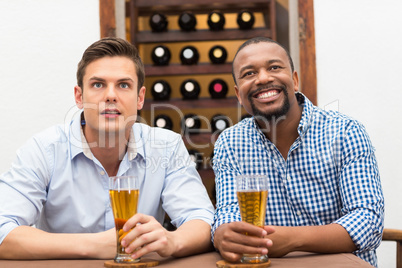 Friends watching football match while having beer