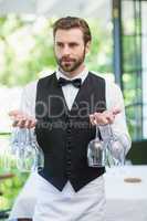 Male waiter holding wine glasses in the restaurant