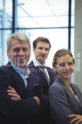 Business executives standing with arms crossed in the office
