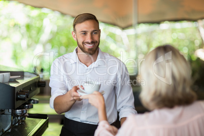 Waiter giving coffee to customer