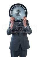 Businessman holding a clock in front of his face