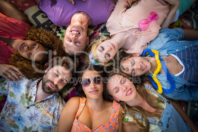 Group of friends lying in a circle at campsite