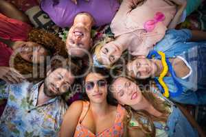 Group of friends lying in a circle at campsite