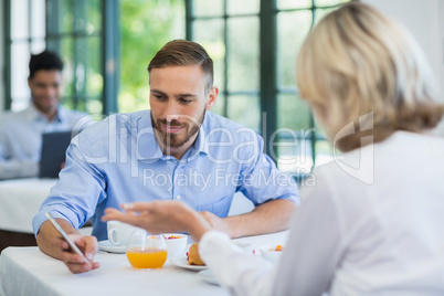 Executives using mobile phone in a restaurant