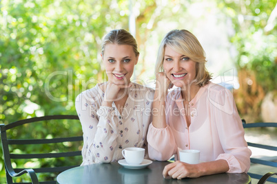 Smiling friends enjoying coffee together