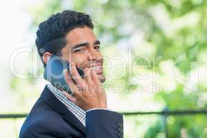 Smiling businessman talking on mobile phone