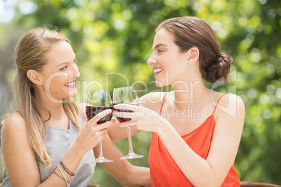 Happy friends toasting wine glasses