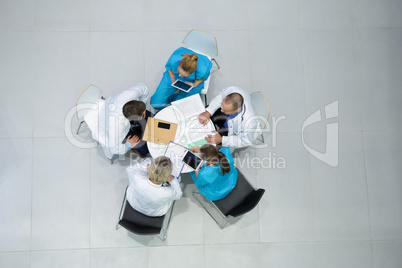 High angle view of doctors and surgeons interacting with each other in meeting