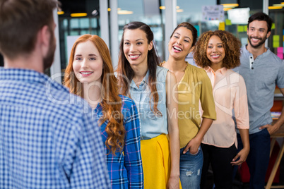 Smiling colleagues standing in front of male executive