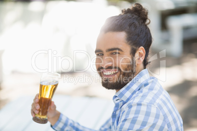 Man holding beer glass in the park on a sunny day