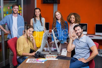 Smiling graphic designers working at desk in office