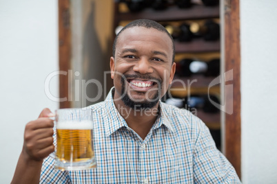 Handsome man smiling while holding beer glass