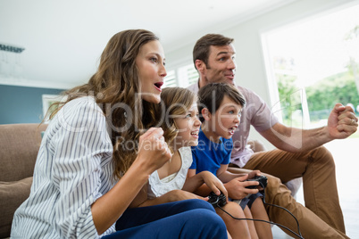 Excited family playing video games together in living room