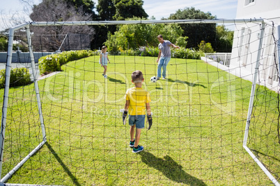 Happy family playing football in the park