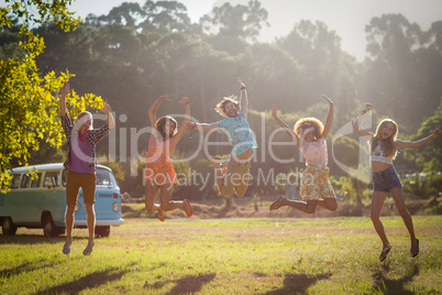 Friends jumping in excitement in park