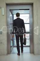 Rear view of businessman walking into an elevator