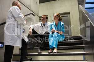 Doctors and surgeons interacting with each other on staircase
