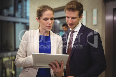 Businessman and businesswoman using digital tablet