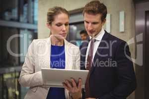 Businessman and businesswoman using digital tablet