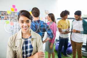 Portrait of happy female graphic designer standing with arms crossed