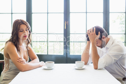 Depressed couple sitting with coffee cup