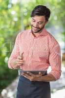 Male waiter using digital tablet