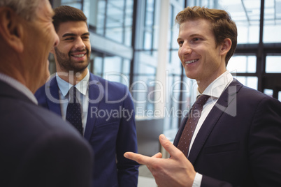 Businessmen interacting with each other in corridor