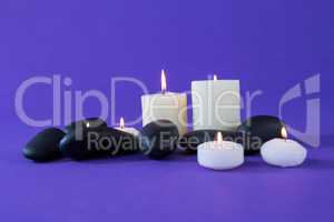 Candles and zen stones on purple background