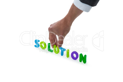 Hand of businessman arranging solution word