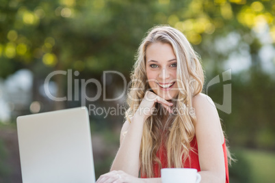 Woman with hand on chin using laptop